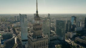WARSAW, POLAND - JUNE 5, 2019. Aerial shot of the Palace of Culture and Science within city centre skyscrapers stock video footage WARSAW, POLAND - JUNE 5, 2019. Aerial shot of the Palace of Culture and Science within city centre skyscrapers stock video footage