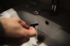 Washing shaving razor in bathroom. Horizontal image stock photo Washing shaving razor in bathroom. Horizontal image stock photo
