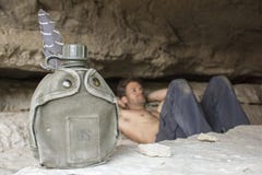 Water canteen and army man resting in cave stock photos Water canteen and army man resting in cave stock photos