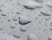 Inspirational heart shaped rain water drop on gray surface