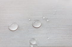 Water drops on white wooden surface made from larch wood covering by oil with wax. stock image Water drops on white wooden surface made from larch wood covering by oil with wax. stock image
