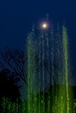 Green lit fountain, touching the Full moon on the sky