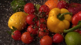 Water raining on selection of fresh fruit and vegetables