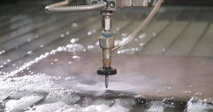 Waterjet high pressure CNC machine is cutting out a holes on a metal sheet.