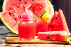 Watermelon slices and juice on wooden table. Glasses with watermelon juice and ice and sliced fresh ripe watermelon. Delicious summer diert concept. Selective Stock Photos Watermelon slices and juice on wooden table. Glasses with watermelon juice and ice and sliced fresh ripe watermelon. Delicious summer diert concept. Selective Stock Photos