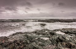 Waves break against the rocky coastline in Newport, Rhode Island. Under a stormy sky Royalty Free Stock Image Waves break against the rocky coastline in Newport, Rhode Island. Under a stormy sky Royalty Free Stock Image