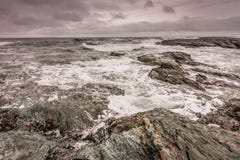 Waves break against the rocky coastline in Newport, Rhode Island. Under a stormy sky Stock Photos Waves break against the rocky coastline in Newport, Rhode Island. Under a stormy sky Stock Photos