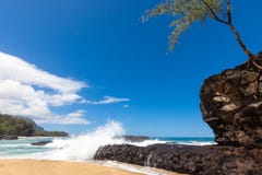 Waves splashing over lava rock on beautiful sandy tropical beach stock images Waves splashing over lava rock on beautiful sandy tropical beach stock images