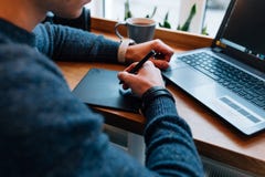 Webontwerper die met interactieve penvertoning werken, die bij koffie zitten stock foto's Webontwerper die met interactieve penvertoning werken, die bij koffie zitten stock foto's