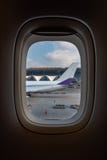 Weergeven van vliegtuigvenster van de vliegtuigstaart in luchthaven en blauwe hemel wordt geparkeerd die royalty-vrije stock afbeeldingen Weergeven van vliegtuigvenster van de vliegtuigstaart in luchthaven en blauwe hemel wordt geparkeerd die royalty-vrije stock afbeeldingen