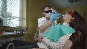 Weibliche geduldige erhaltene Behandlung mit zahnmedizinischer UV-Licht-Ausrüstung Zahnmedizinisches Büro stock footage Weibliche geduldige erhaltene Behandlung mit zahnmedizinischer UV-Licht-Ausrüstung Zahnmedizinisches Büro stock footage