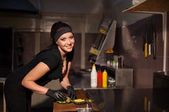 Weiblicher Chef, der Nahrung in der Küche des Restaurant Burgers zubereitet lizenzfreies stockbild Weiblicher Chef, der Nahrung in der Küche des Restaurant Burgers zubereitet lizenzfreies stockbild