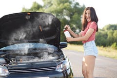 Weiblicher Fahrer des deprimierten Brunette steht brocken nahe Auto mit geöffneter Haube, Versuche, um technisches Problem durch lizenzfreie stockfotografie Weiblicher Fahrer des deprimierten Brunette steht brocken nahe Auto mit geöffneter Haube, Versuche, um technisches Problem durch lizenzfreie stockfotografie