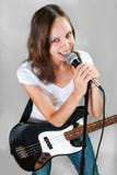 Weiblicher Sänger mit Mikrofon und Bass-Gitarre auf Grau stockbild Weiblicher Sänger mit Mikrofon und Bass-Gitarre auf Grau stockbild