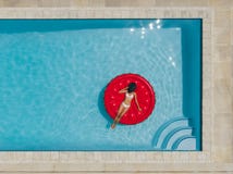 Weibliches Ein Sonnenbad nehmen auf sich hin- und herbewegender Matratze im Pool lizenzfreie stockfotografie Weibliches Ein Sonnenbad nehmen auf sich hin- und herbewegender Matratze im Pool lizenzfreie stockfotografie