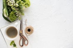 Weibliches flatlay mit Blumen und ccoffee auf weißer Tischplatte stockfotografie Weibliches flatlay mit Blumen und ccoffee auf weißer Tischplatte stockfotografie