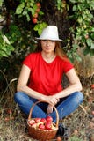 Weibliches Freienporträt Eine glückliche Frau von mittlerem Alter sitzt unter einem Baum in einem Apfelgarten nahe einem vollen K lizenzfreie stockfotos Weibliches Freienporträt Eine glückliche Frau von mittlerem Alter sitzt unter einem Baum in einem Apfelgarten nahe einem vollen K lizenzfreie stockfotos