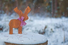 Weihnachten-Baumspielzeugrotwild mit einem Band auf dem Schnee Mit einem Kopieraum lizenzfreie stockfotografie Weihnachten-Baumspielzeugrotwild mit einem Band auf dem Schnee Mit einem Kopieraum lizenzfreie stockfotografie