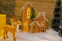 Weihnachtsdekorationen, flaumiges Ren, kleines hölzernes und beleuchtetes Häuschen lizenzfreies stockbild Weihnachtsdekorationen, flaumiges Ren, kleines hölzernes und beleuchtetes Häuschen lizenzfreies stockbild