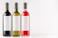 Weinflaschensammlung - rot, grün, schwarz- mit leeren weißen Aufklebern auf weißem hölzernem Brett, Spott oben, Kopienraum stockbilder Weinflaschensammlung - rot, grün, schwarz- mit leeren weißen Aufklebern auf weißem hölzernem Brett, Spott oben, Kopienraum stockbilder