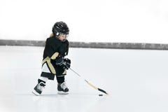 Weinig leuk blond meisje speelt hockey in volledig materiaal op het stadion royalty-vrije stock afbeeldingen Weinig leuk blond meisje speelt hockey in volledig materiaal op het stadion royalty-vrije stock afbeeldingen