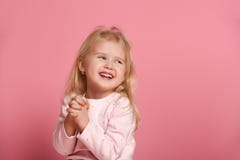Weinig leuk blonde van het meisjeskind in een roze kostuum is schuw op een roze achtergrond royalty-vrije stock afbeelding Weinig leuk blonde van het meisjeskind in een roze kostuum is schuw op een roze achtergrond royalty-vrije stock afbeelding
