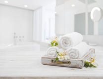 Weinlesefach, Badekurorttücher und Orchideenblumen über unscharfem Badezimmer Stockfotografie Weinlesefach, Badekurorttücher und Orchideenblumen über unscharfem Badezimmer Stockfotografie