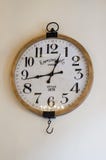 Weinlesewanduhr auf einer weißen Wand lizenzfreie stockfotografie Weinlesewanduhr auf einer weißen Wand lizenzfreie stockfotografie