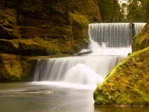 Weir rochoso no rio pequeno da montanha O córrego está fluindo sobre blocos e faz a água leitosa Imagens de Stock Weir rochoso no rio pequeno da montanha O córrego está fluindo sobre blocos e faz a água leitosa Imagens de Stock
