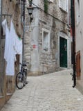 WEISSE WÄSCHEREI, FAHRRAD UND EINE SCHMALE KOPFSTEIN-STRASSE, ROVINJ, KROATIEN lizenzfreie stockfotos WEISSE WÄSCHEREI, FAHRRAD UND EINE SCHMALE KOPFSTEIN-STRASSE, ROVINJ, KROATIEN lizenzfreie stockfotos