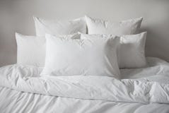 Weiße Kissen, Daunendecke und duvetcase in einem Bett Weicher Fokus lizenzfreie stockfotografie Weiße Kissen, Daunendecke und duvetcase in einem Bett Weicher Fokus lizenzfreie stockfotografie