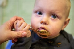 Wenig Baby lernen, durch selbst mit einem Löffel zu essen lizenzfreie stockbilder Wenig Baby lernen, durch selbst mit einem Löffel zu essen lizenzfreie stockbilder