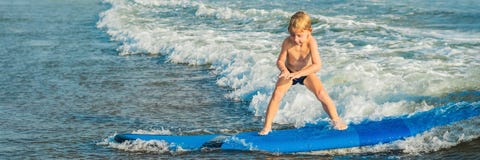 Wenig Junge, der auf tropischen Strand surft Kind auf Brandungsbrett auf Meereswogen Aktiver Wassersport für Kinder Kinderschwimm stockfotos Wenig Junge, der auf tropischen Strand surft Kind auf Brandungsbrett auf Meereswogen Aktiver Wassersport für Kinder Kinderschwimm stockfotos