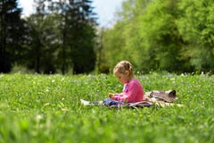 Wenig Mädchen, das auf einer grünen Wiese unter Wiesenblumen stillsteht stockbilder Wenig Mädchen, das auf einer grünen Wiese unter Wiesenblumen stillsteht stockbilder