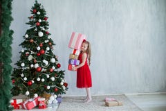 Wenig Mädchen öffnet Weihnachtsgeschenke am Feiertagshaus des neuen Jahres des Weihnachtsbaums lizenzfreie stockfotografie Wenig Mädchen öffnet Weihnachtsgeschenke am Feiertagshaus des neuen Jahres des Weihnachtsbaums lizenzfreie stockfotografie