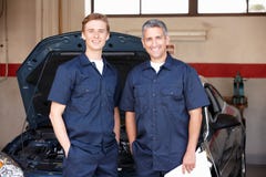 Werktuigkundigen die zich voor auto bevinden royalty-vrije stock afbeelding Werktuigkundigen die zich voor auto bevinden royalty-vrije stock afbeelding