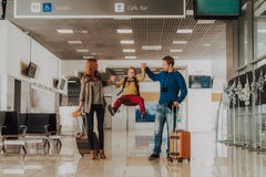 Wesoło rodzina ma zabawę z dzieciakiem przy lotniskiem fotografia stock Wesoło rodzina ma zabawę z dzieciakiem przy lotniskiem fotografia stock