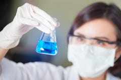 Wetenschapper die blauwe reageerbuis in het laboratorium bekijken royalty-vrije stock foto's Wetenschapper die blauwe reageerbuis in het laboratorium bekijken royalty-vrije stock foto's