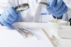 Wetenschapper het testen zaden bij het laboratorium Witte lijst en verschillende reageerbuizen, chemiekommen op het royalty-vrije stock afbeelding Wetenschapper het testen zaden bij het laboratorium Witte lijst en verschillende reageerbuizen, chemiekommen op het royalty-vrije stock afbeelding