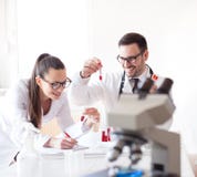 Wetenschappers in laboratorium met microscoop stock afbeeldingen Wetenschappers in laboratorium met microscoop stock afbeeldingen