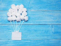 White absorbent cotton balls and cotton buds on wooden blue background royalty free stock photography White absorbent cotton balls and cotton buds on wooden blue background royalty free stock photography
