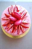 White cake with pink drips decorated with macarons, strawberries and sprinkles on golden cake board. royalty free stock photos White cake with pink drips decorated with macarons, strawberries and sprinkles on golden cake board. royalty free stock photos