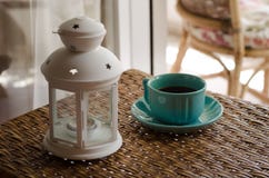 White Candle Lantern Beside of Blue Ceramic Coffee Mug on Wicker Table Stock Image White Candle Lantern Beside of Blue Ceramic Coffee Mug on Wicker Table Stock Image