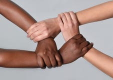 White Caucasian female and black African American hands holding together against racism and xenophobia