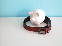 White ceramic piggy bank with brown leather belt around royalty free stock photos White ceramic piggy bank with brown leather belt around royalty free stock photos