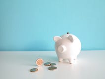 White ceramic piggy bank with euro coins on the table royalty free stock photos White ceramic piggy bank with euro coins on the table royalty free stock photos