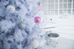 White Christmas tree decorated with silver and pink ornaments at the piano background.Winter scene. New Year decoration stock photography White Christmas tree decorated with silver and pink ornaments at the piano background.Winter scene. New Year decoration stock photography