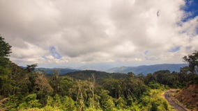 Cloudy Sky over Tropical Forest Hills Road in Vietnam. White cloudy sky over green tropical forest hill slopes and ground road in Vietnam Royalty Free Stock Images Cloudy Sky over Tropical Forest Hills Road in Vietnam. White cloudy sky over green tropical forest hill slopes and ground road in Vietnam Royalty Free Stock Images