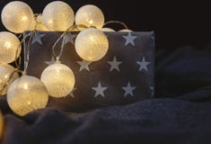 White cotton ball light garland in a grey basket with stars sparkling at home. close up, bright lights, festive atmosphere stock photo White cotton ball light garland in a grey basket with stars sparkling at home. close up, bright lights, festive atmosphere stock photo