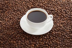 White Cup Of Black Coffee Standing On Roasted Coffee Beans. Royalty Free Stock Image